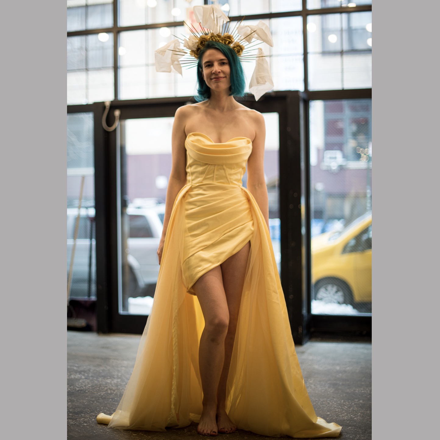 a woman in a yellow dress, wearing a kleenex crown