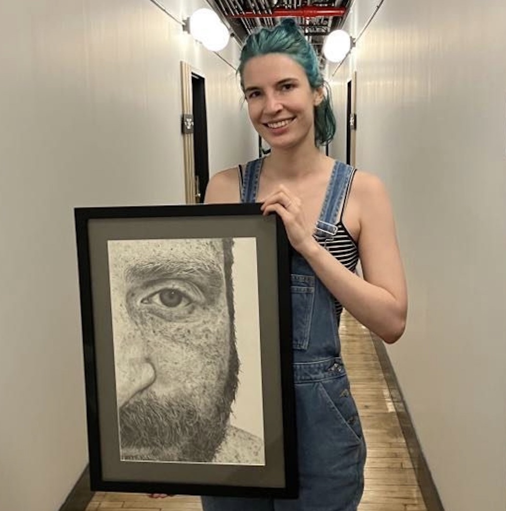 a woman holding a drawing of a man